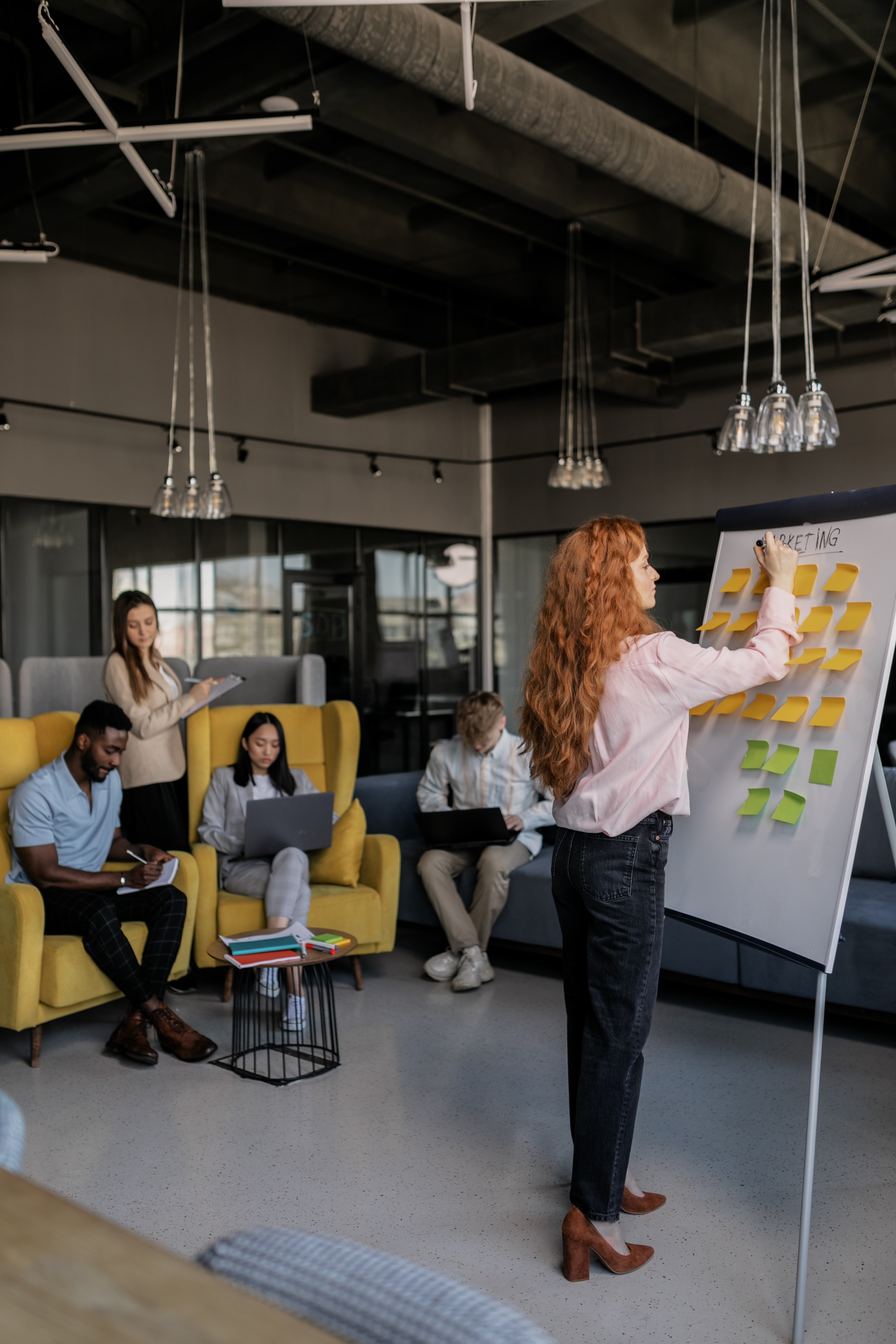 Person adding a title to a whiteboard with post-its