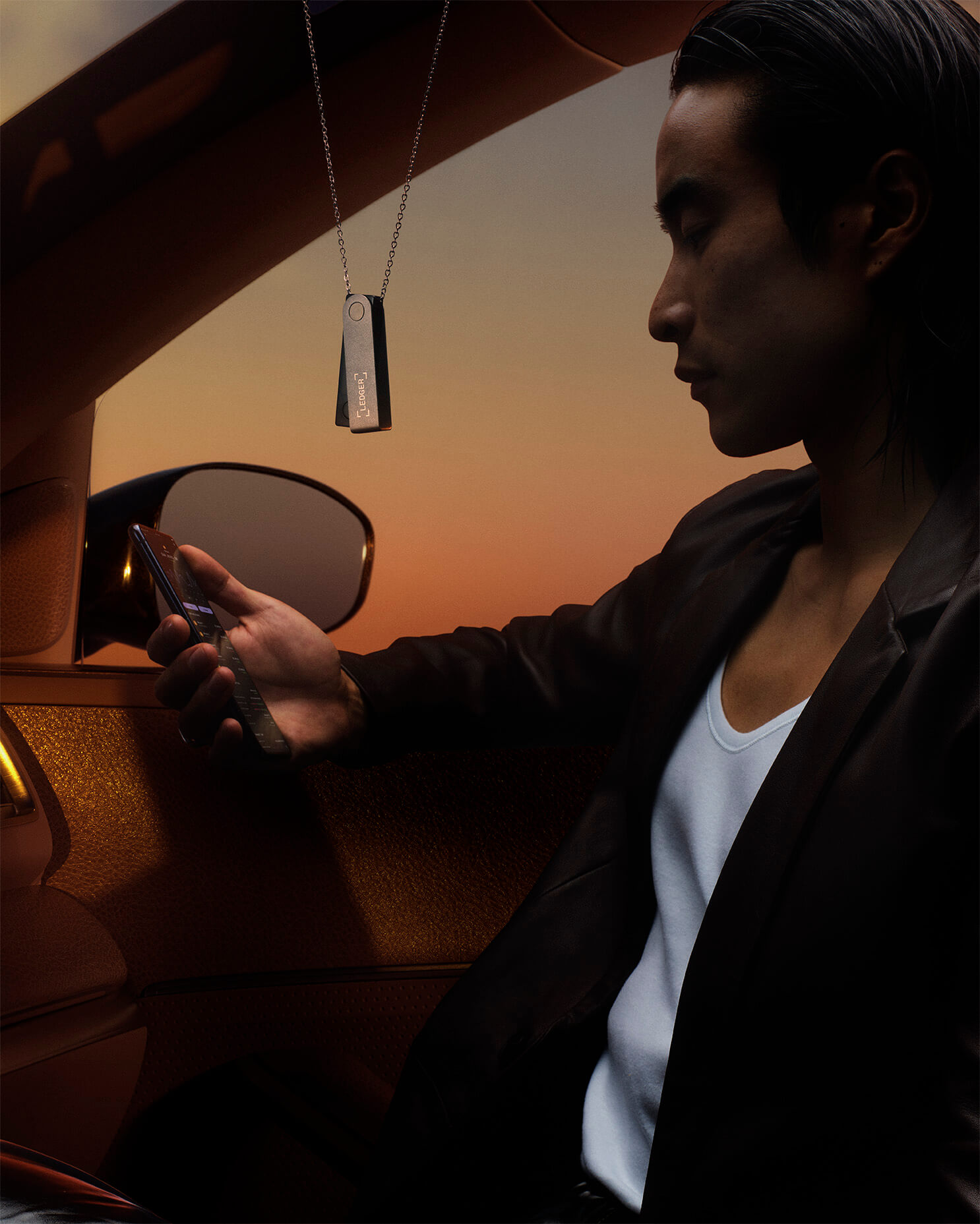 Image of a person in a car with a Ledger Device hanging from the ceiling